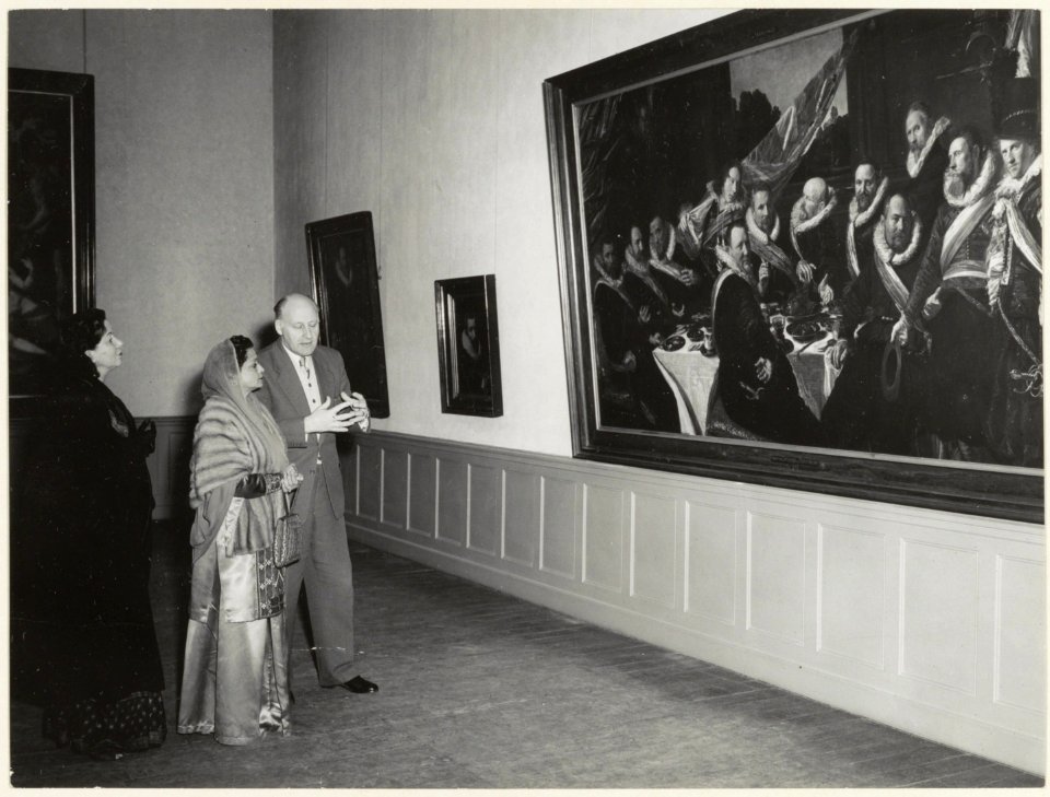 Dhr. H.P. Baard, direkteur van het Frans Halsmuseum leidt een buitenlandse bezoekster rond. NL-HlmNHA 54004076