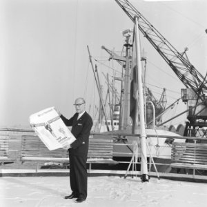 Dhr. B. Haverman , directeur ICEM, toont aan boord HAL-schip affiche ICEM-zegels, Bestanddeelnr 918-6931