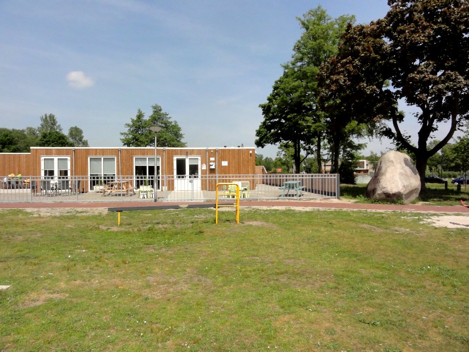 Dolphia (Enschede) Transvaalplein, links huiskamer van de buurt, rechts de kei, op de achtergrond tussen de bomen De Kei