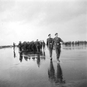 Door regenplassen marcherende militairen bij het defilé, Bestanddeelnr 255-7700