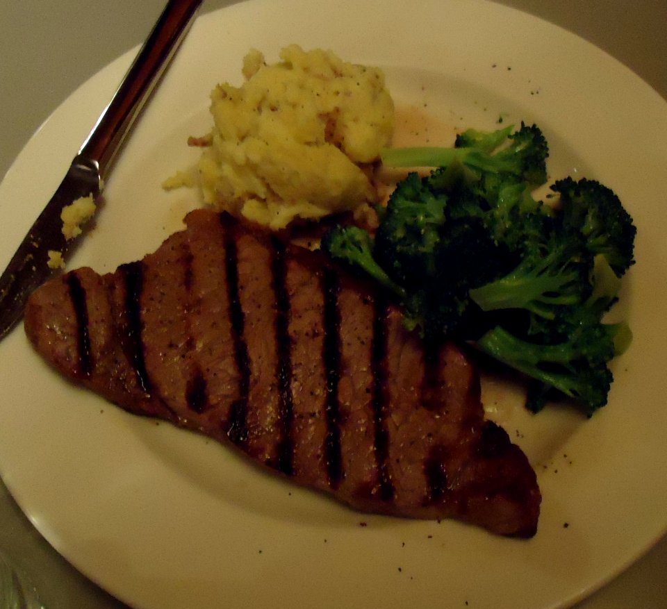 Dinner at a restaurant with steak and potatoes and broccoli
