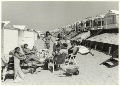 Eigenaren van strandhuisjes in de zon. NL-HlmNHA 54013180