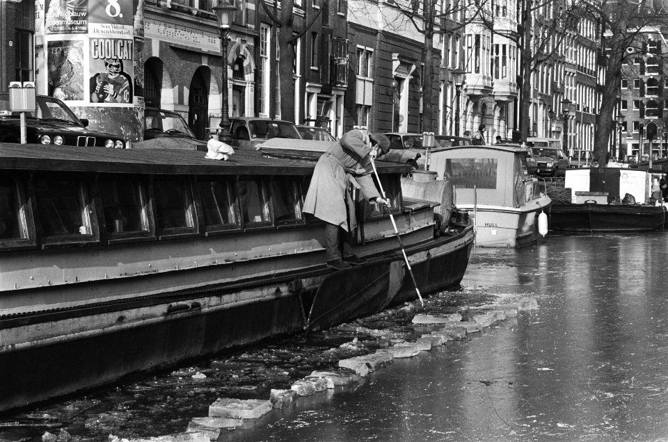 Eigenaar van schip op Keizersgracht hakt ijs rond zijn vaartuig weg, Bestanddeelnr 933-5641