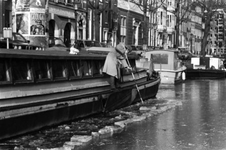 Eigenaar van schip op Keizersgracht hakt ijs rond zijn vaartuig weg, Bestanddeelnr 933-5641