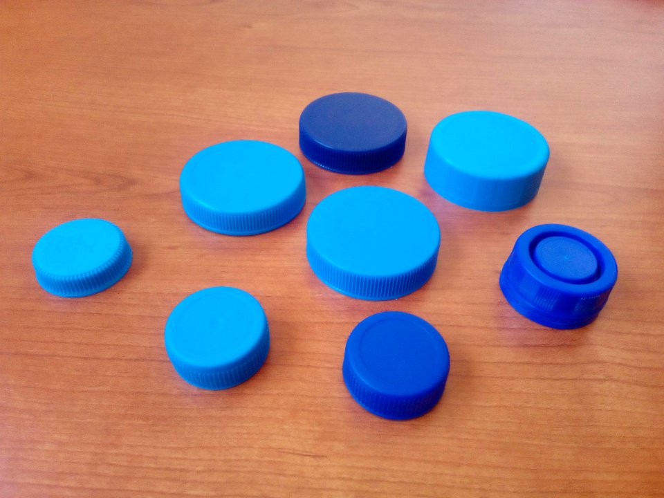 Eight blue plastic bottle lids