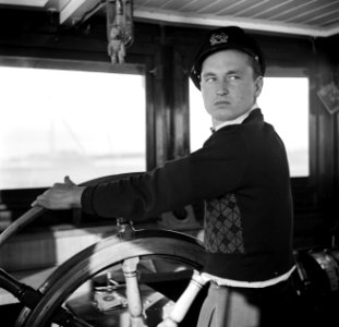 Eerste stuurman Hans aan het roer van de Damco 9, Bestanddeelnr 254-1403
