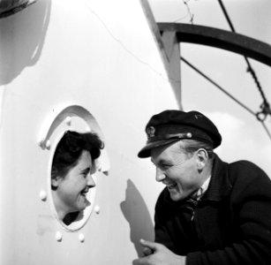 Eerste stuurman Hans met zijn verloofde Annie bij een patrijspoort van de Damco , Bestanddeelnr 254-1456