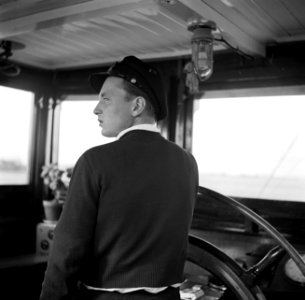 Eerste stuurman Hans aan het roer van de Damco 9, Bestanddeelnr 254-1402
