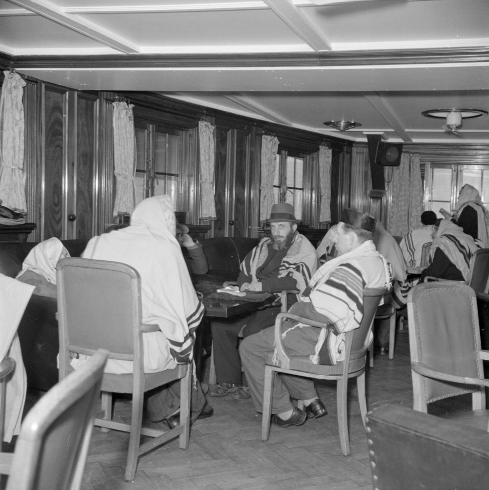 Emigranten (oliem) op weg naar Israel, gehuld in gebedsmantels, in de lounge v…, Bestanddeelnr 255-1114