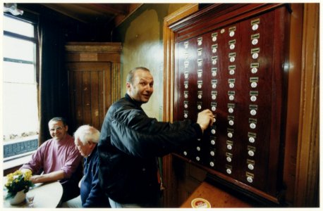 Emiel van der Veldt bij de speciale spaarkast in café Bartje De kast biedt de mogelijkheid geld in te leggen voor de jaarlijkse feestweek. NL-HlmNHA 54037218