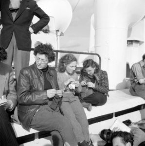 Emigranten (oliem) met een breiwerkje aan dek van het schip dat hen naar Israel , Bestanddeelnr 255-1104