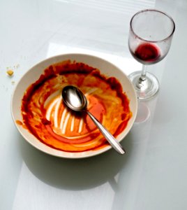 Empty tomato soup dish and wine glass