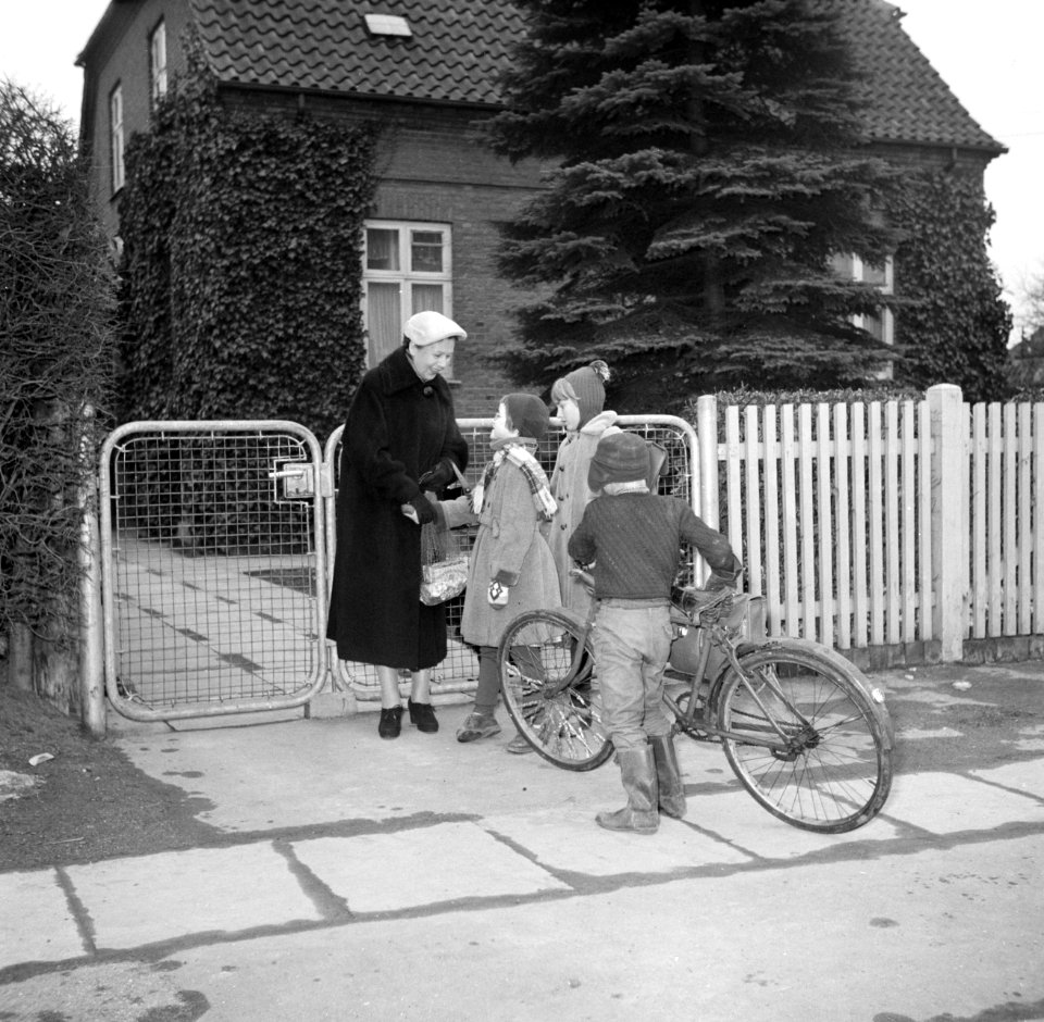 Ella Hedtoft begroet kinderen voor het toegangshek van de tuin, Bestanddeelnr 252-8984