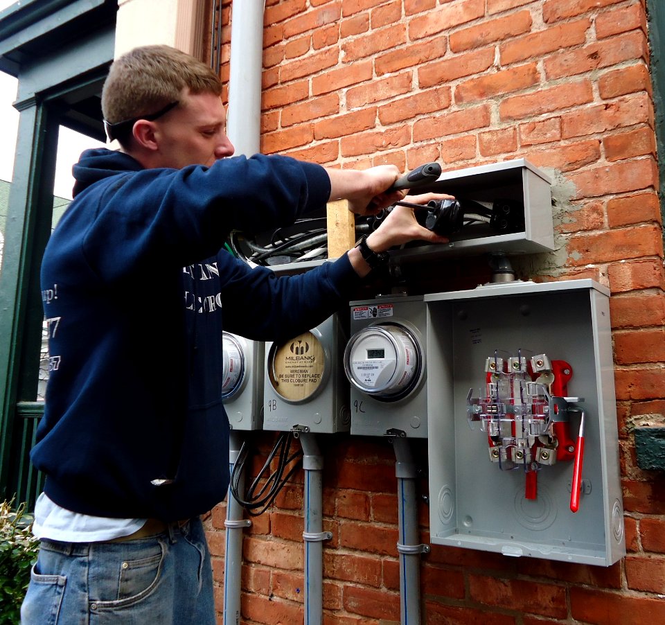 Electrician installing outdoor connections on multifamily house