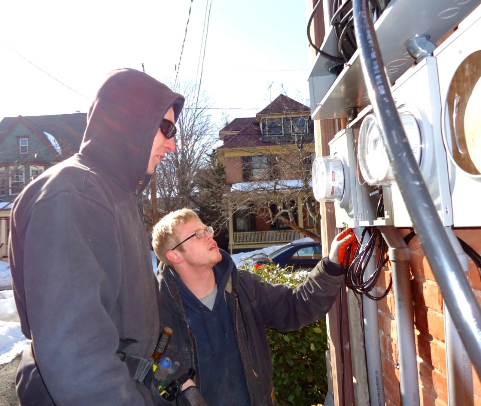 Electricians inspecting panels for separate house meters on multifamily in NJ