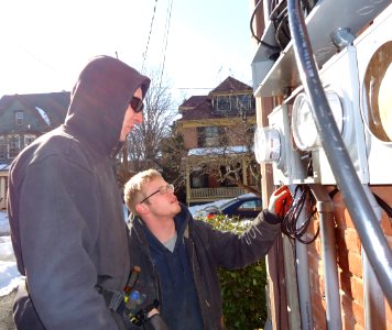Electricians inspecting panels for separate house meters on multifamily in NJ photo