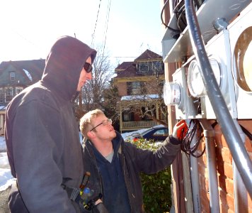 Electricians inspecting panels for separate house meters on multifamily in NJ