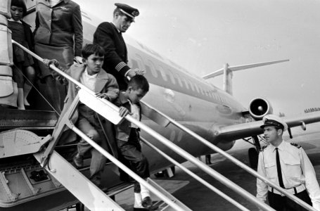 Een KLM-employe begeleidt de jongens op de vliegtuigtrap, Bestanddeelnr 919-2552