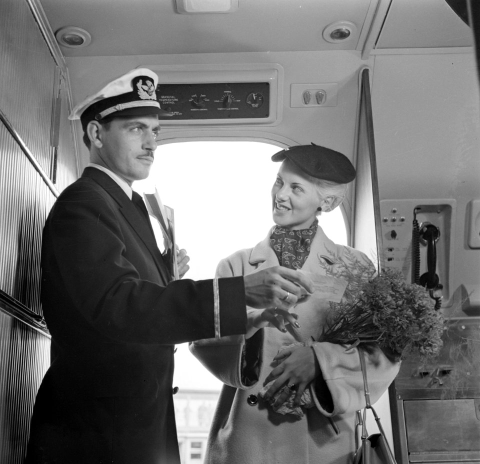 Een KLM-purser verwelkomt een reiziger in de cabine en duidt haar de ziplaats, Bestanddeelnr 252-1234