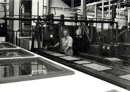 Een kijkje in de Union-fabriek vaan de Paul Krugerkade, waar aan de lopende band door Dhr. Beringen chocolaatjes gegoten worden. Aangekocht in 1981 van fotograaf C. de Boer. - Negatiefnummer, NL-HlmNHA 54011547