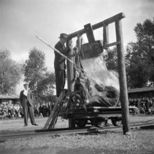 Een lorry rijdt onder een ton met water door De bestuurder krijgf een waterstor, Bestanddeelnr 900-7383 photo