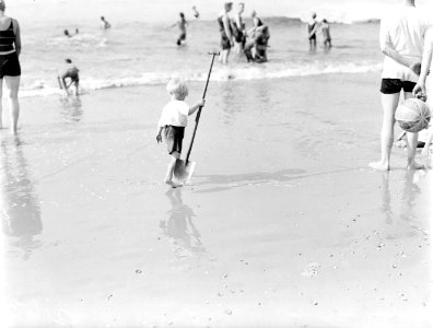Een kind met schop op het strand in Scheveningen, Bestanddeelnr 252-1440