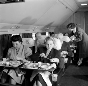 Een KLM stewardess serveert een maaltijd aan boord van een KLM passagiersvliegtu, Bestanddeelnr 252-1246