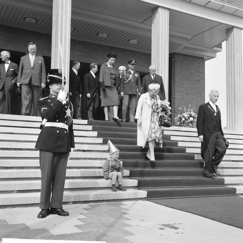 Een klein jochie met feestmuts zit op de trappen van het stadhuis, terwijl konin, Bestanddeelnr 917-7976