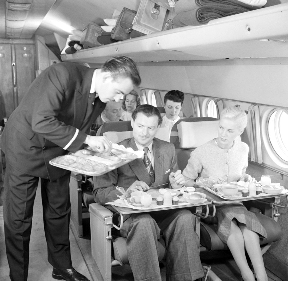 Een KLM-purser serveert de maaltijd tijdens de vlucht in een KLM passagiersvlieg, Bestanddeelnr 252-1244