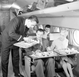 Een KLM-purser serveert de maaltijd tijdens de vlucht in een KLM passagiersvlieg, Bestanddeelnr 252-1244