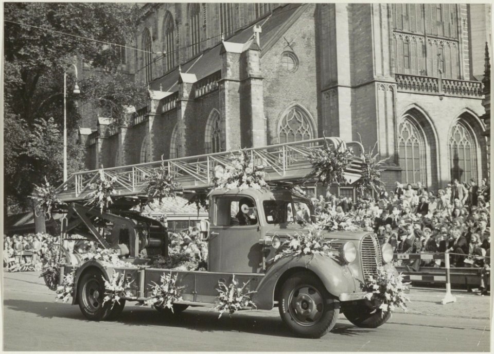 Een ladderwagen van de Brandweer neemt deel als praalwagen aan het Bloemencorso op de Grote Markt. NL-HlmNHA 54010472