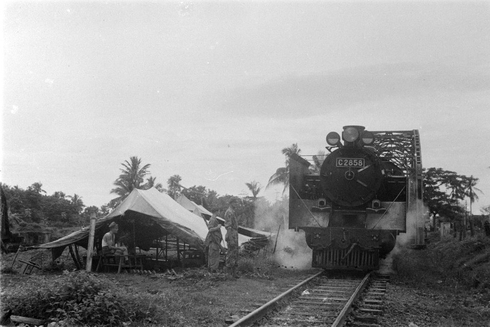 Een locomotief passeert een Nederlandse controlepost bij een spoorbrug, Bestanddeelnr 120A-5-1