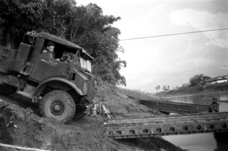Een legertruck manoevreert op de oever van een rivier om een ponton op te rijden, Bestanddeelnr 12044