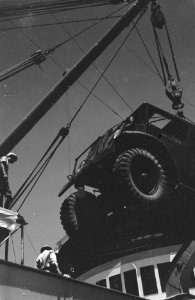 Een legertruck wordt aan boord van een vrachtschip geladen, Bestanddeelnr 457-1-1