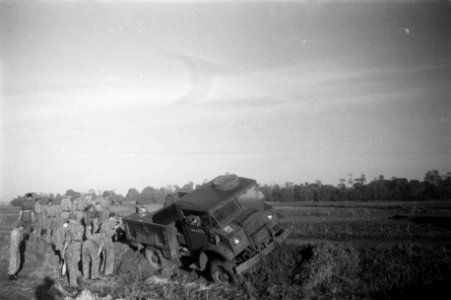 Een legertruck is van de weg geraakt en zit vast in een berm Met vereende krach, Bestanddeelnr 12052
