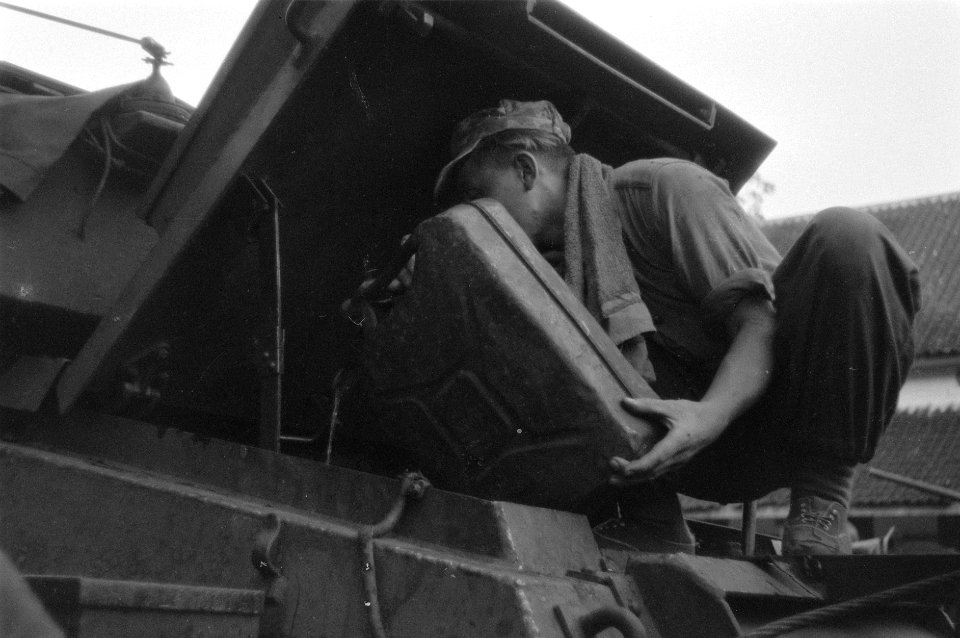 Een militair giet vanuit een jerrycan benzine in de tank van de CT-15 pantserwa, Bestanddeelnr 2819