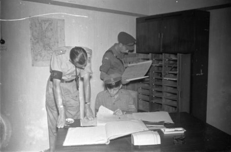 Een luitenant van de Marechaussee (Militaire Politie) bekijkt een register samen, Bestanddeelnr 117-2-5