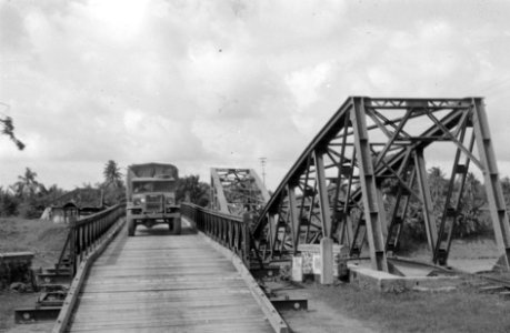 Een legertruck rijdt over een door de genie aangelegde noodbrug. Rechts de verw, Bestanddeelnr 2997