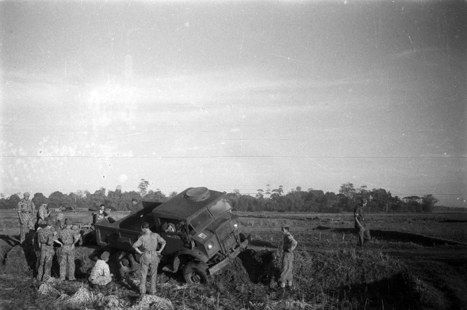 Een legertruck is van de weg geraakt en zit vast in een berm Met vereende krach, Bestanddeelnr 12054