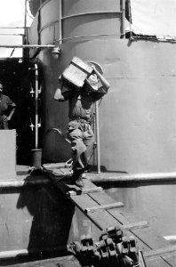 Een militair draagt een kist van een schip, Bestanddeelnr 5598