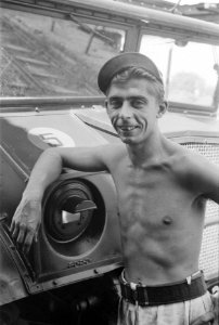 Een militair met ontbloot bovenlijf poseert bij een legertruck, Bestanddeelnr 198-3-2
