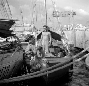 Een man bij een boot op de drijvende markt aan de De Ruijterkade in Willemstad o, Bestanddeelnr 252-7263