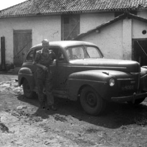 Een militair poseert bij een stafauto, Bestanddeelnr 6968