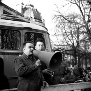 Een man geeft aanwijzingen door de megafoon om boven het geluid van de motor uit, Bestanddeelnr 254-0068