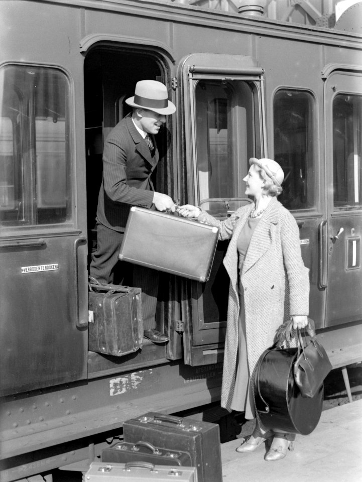 Een man helpt model Eva Waldschmidt met haar koffer in de deur van een treincoup, Bestanddeelnr 189-1269
