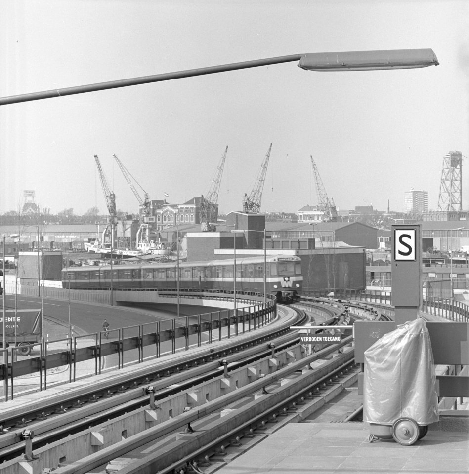 Een metrotrein komt uit de metrotunnel onder de Nieuwe Maas en rijdt ter hoogte van de Parallelweg richting station Rijnhaven Rotterdam - NL-RtSA 4121 10660-1-01