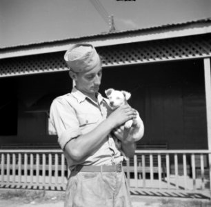 Een militair met een jong hondje in een militair kamp in Savaneta op Aruba, Bestanddeelnr 252-8003