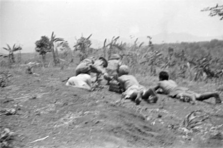 Een militair krijgt munite aangereikt van een liggende Indonesische man die bloo, Bestanddeelnr 62-3-3