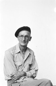 Een man in uniform poseert Hij draagt een bril en een donkere baret, Bestanddeelnr 203-5-1