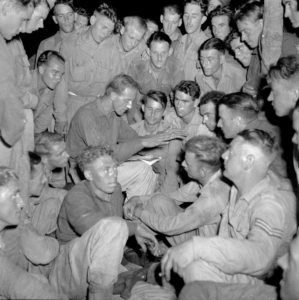 Een militair leest 's avonds een spannend verhaal voor in het kamp Morib Beach o, Bestanddeelnr 255-8264